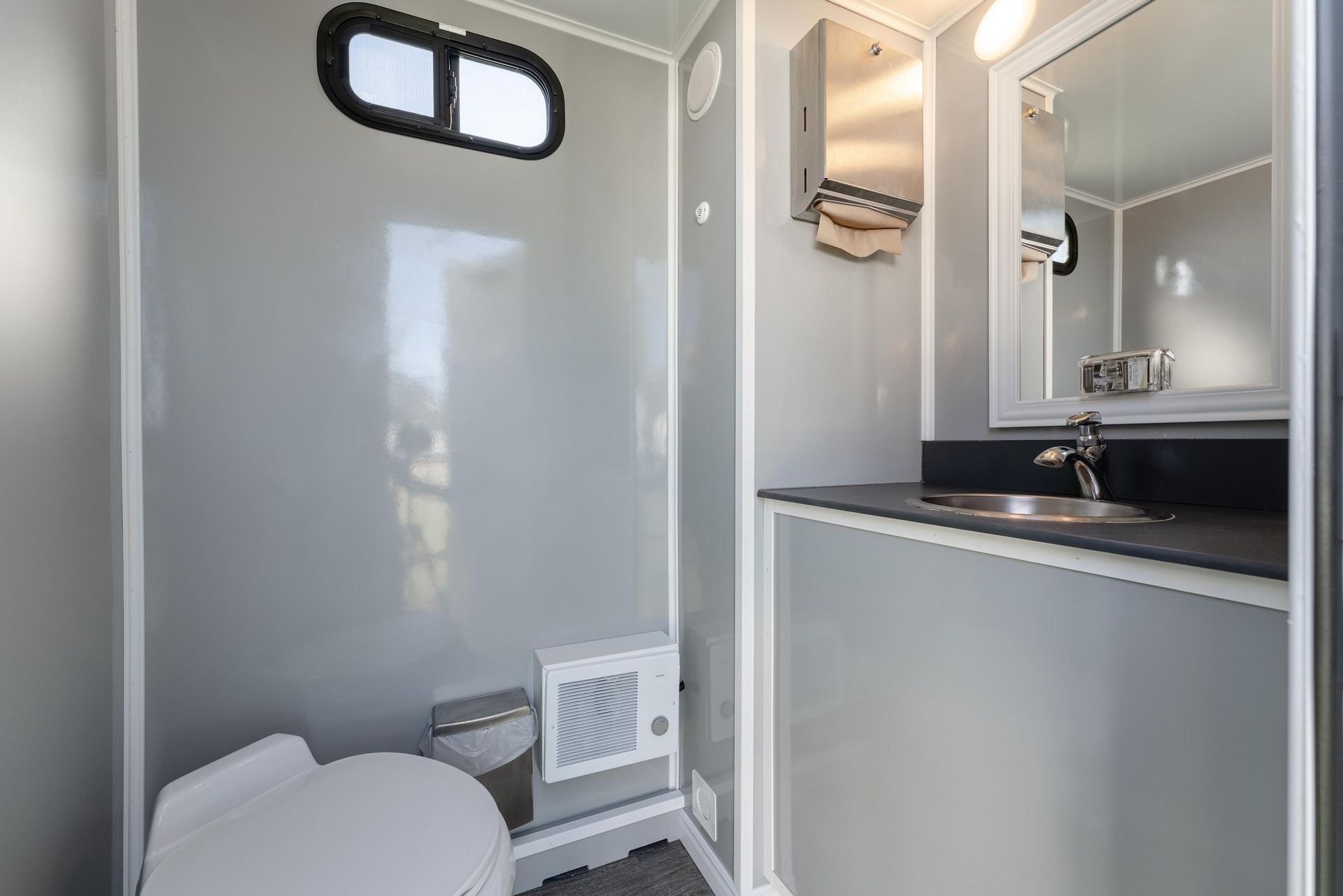A bathroom with a toilet, sink, and mirror