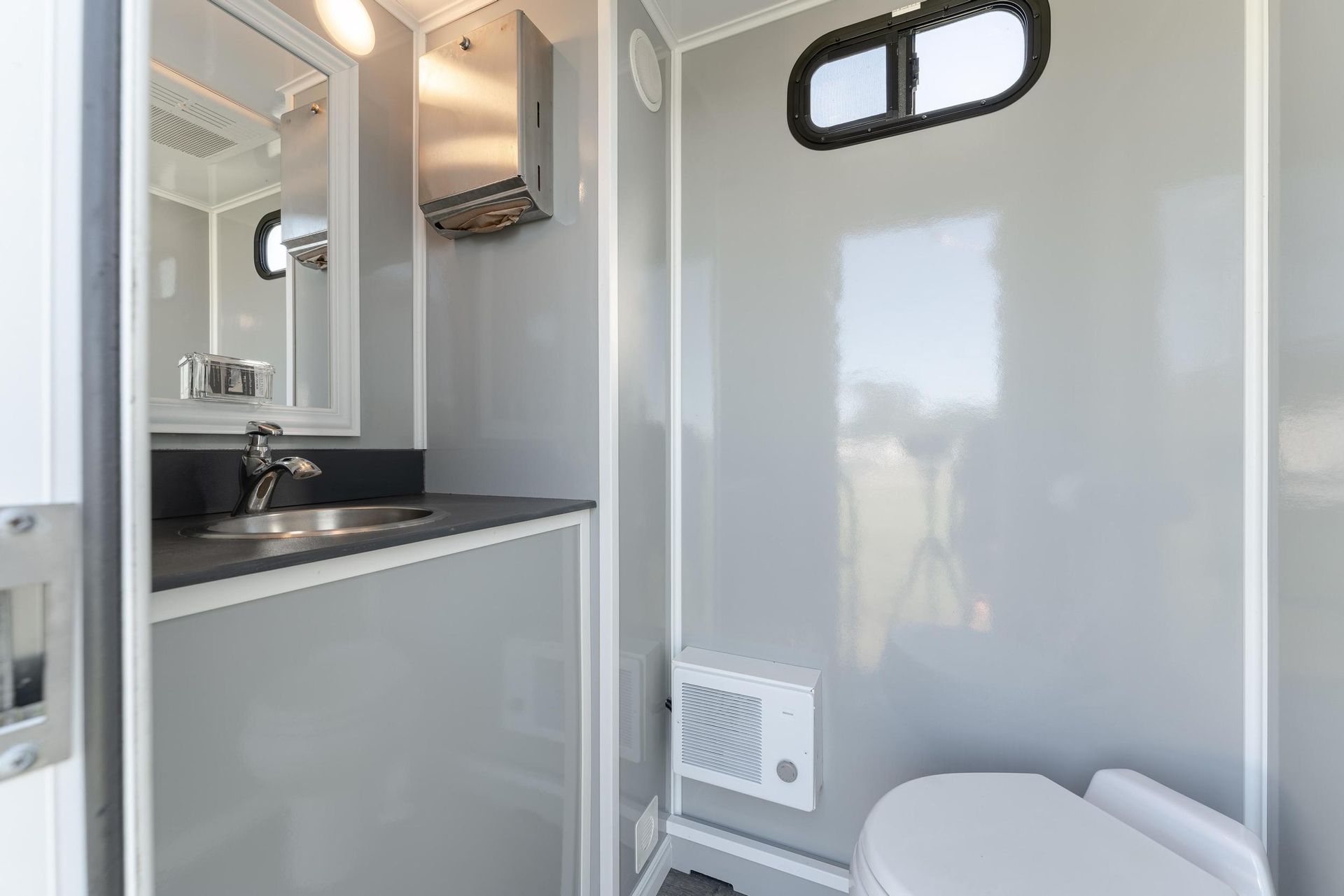 A bathroom with a toilet, sink, and mirror