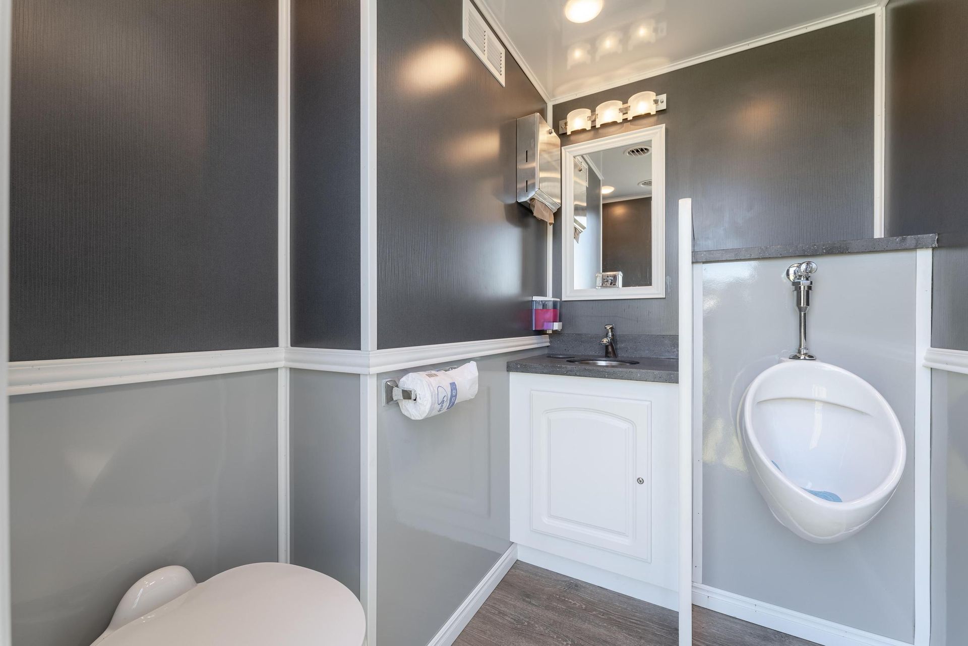A bathroom with a toilet, sink, and urinal