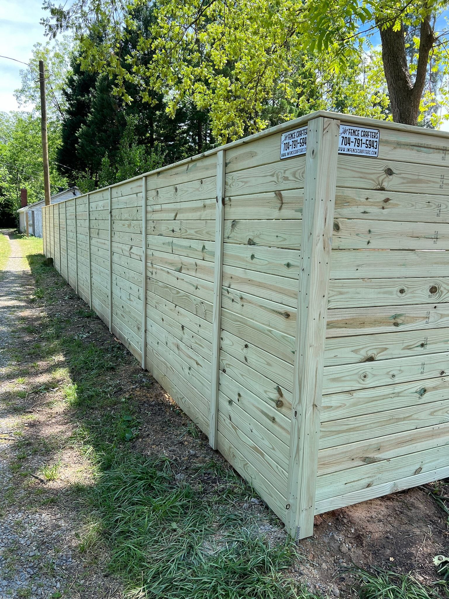 Wooden privacy fence in a grassy area.