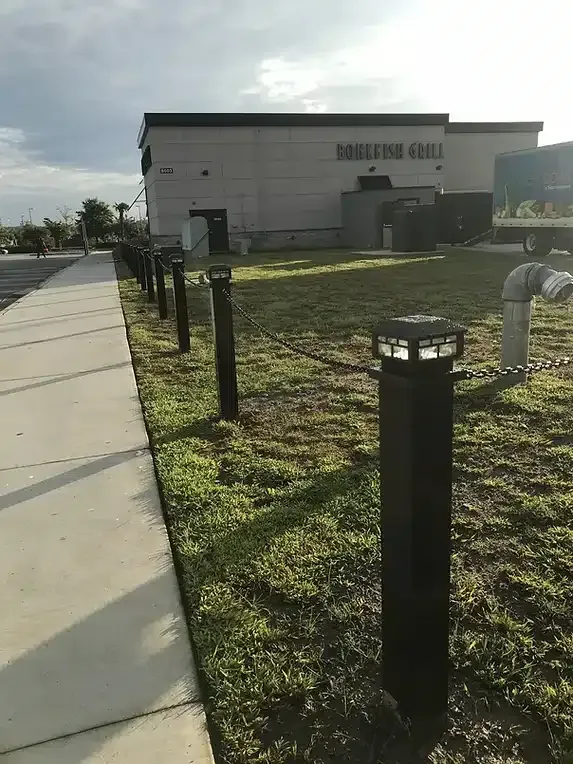 Black bollard lights along a sidewalk. Restaurant 