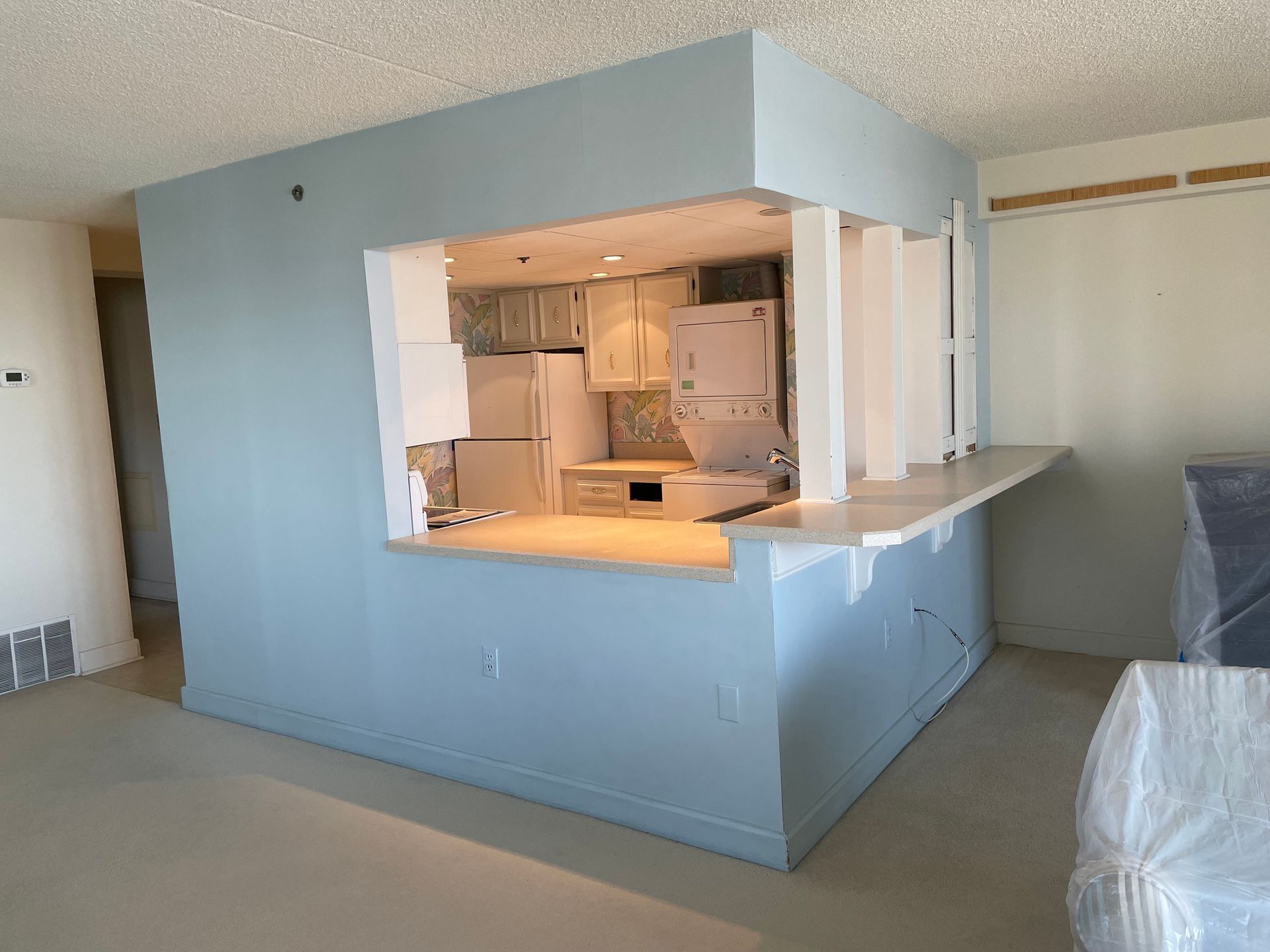 A kitchen with a counter and a refrigerator in a house