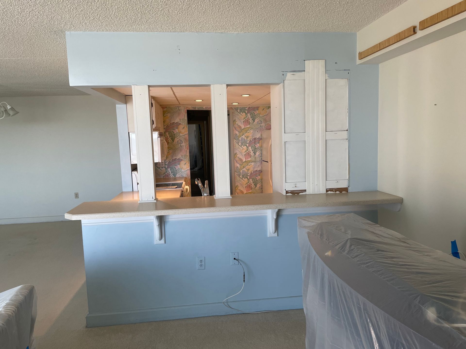 A kitchen with blue walls and white cabinets is being remodeled.