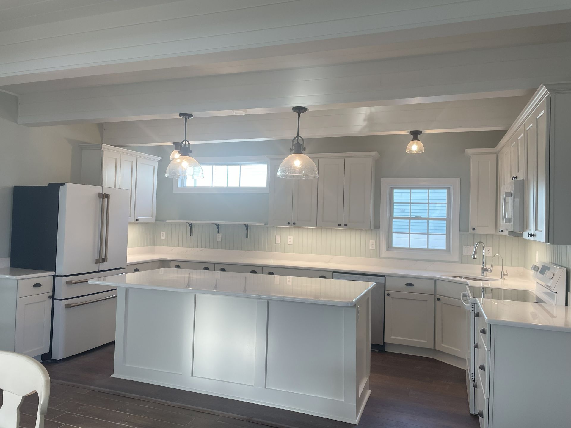 White kitchen showing from a slightly off center of a front view of the kitchen