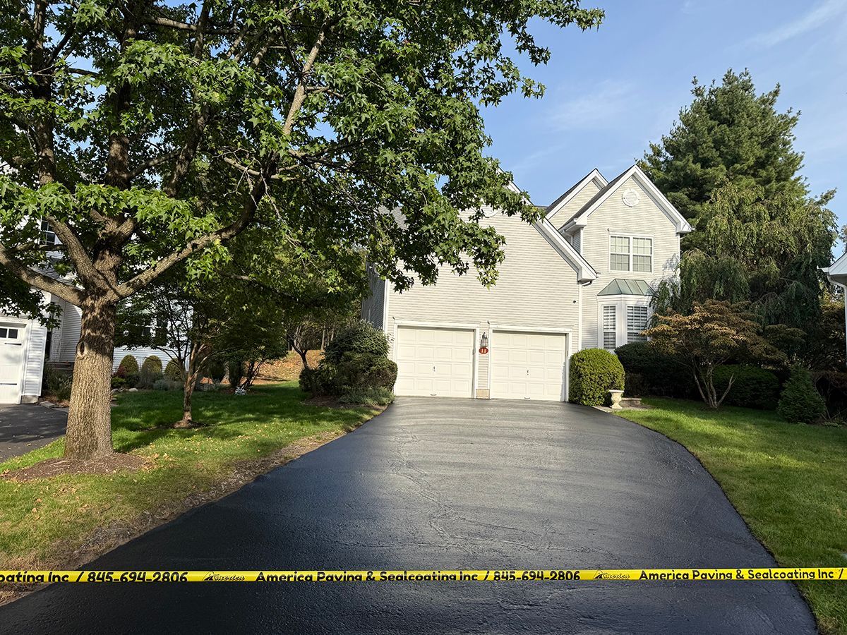 Two-story house with a two-car garage, black driveway, and yellow caution tape across the bottom.