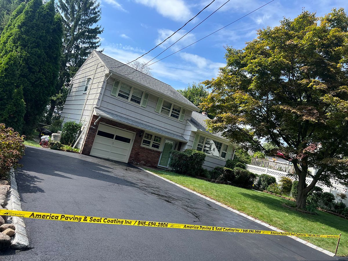 House with slanted driveway, caution tape. White two-story house, garage, grass, trees, overhead wires, sunny day.