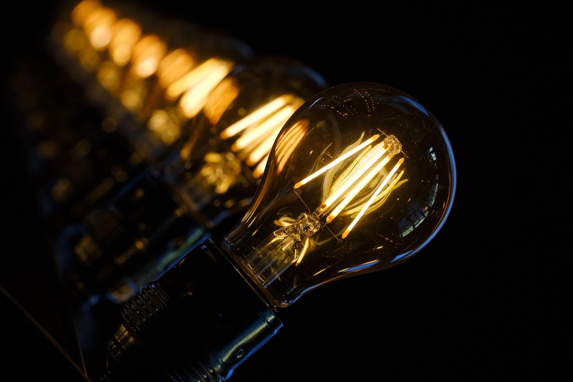 Row of glowing Edison light bulbs in a dark setting