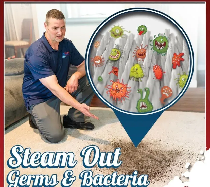 A man is kneeling on the floor with a picture of germs and bacteria behind him
