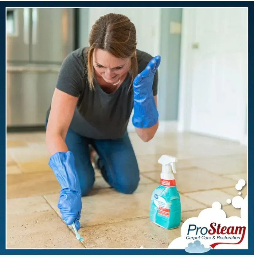 A woman wearing blue gloves is cleaning a tile floor