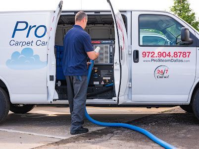 A man is standing in front of a pro carpet care van.