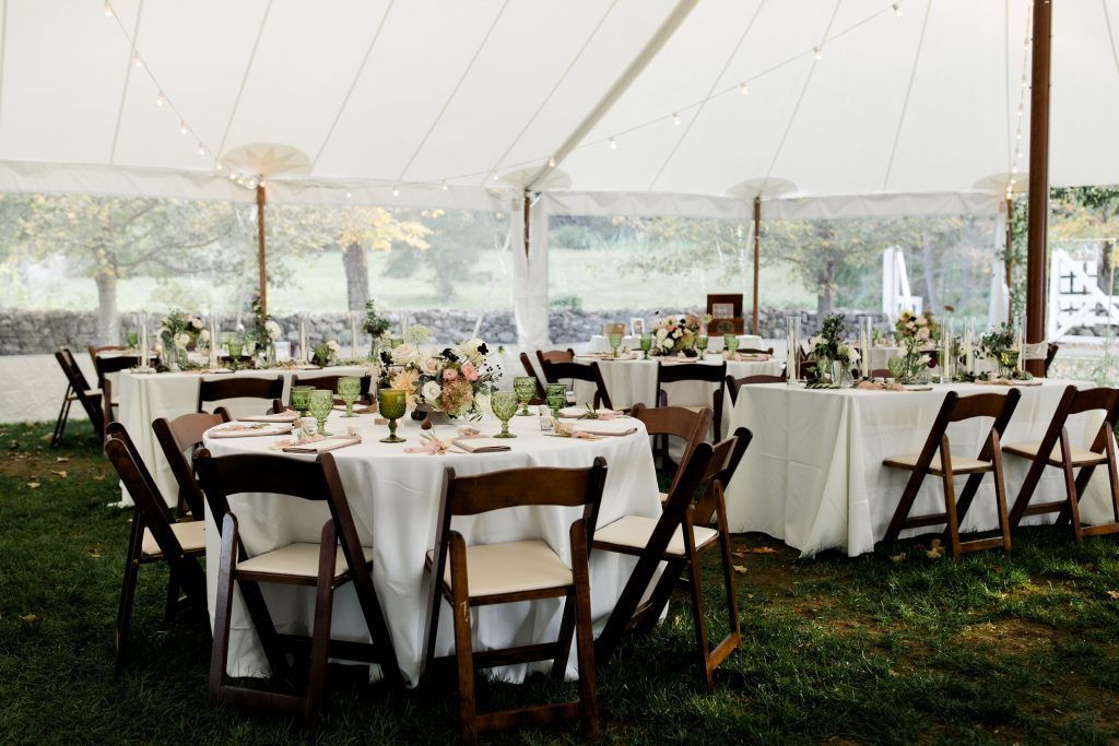 a tent with tables and chairs set up for a wedding reception