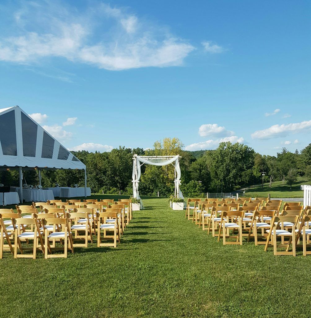 rows of wooden blonde folding chair in a grassy field