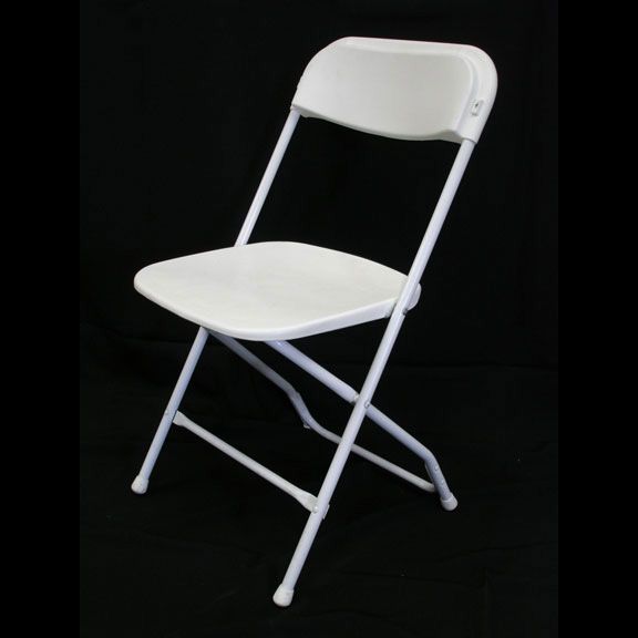 a white folding chair is sitting on a black surface