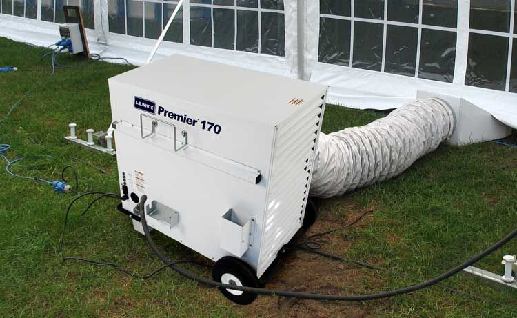 A white machine with a hose attached to it is sitting in front of a tent.