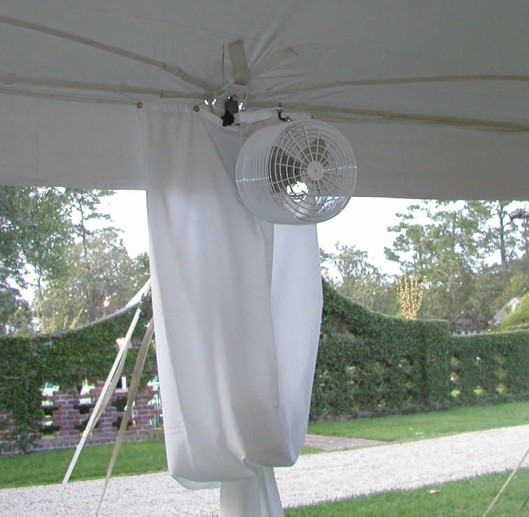 A fan is hanging from the ceiling of a tent.
