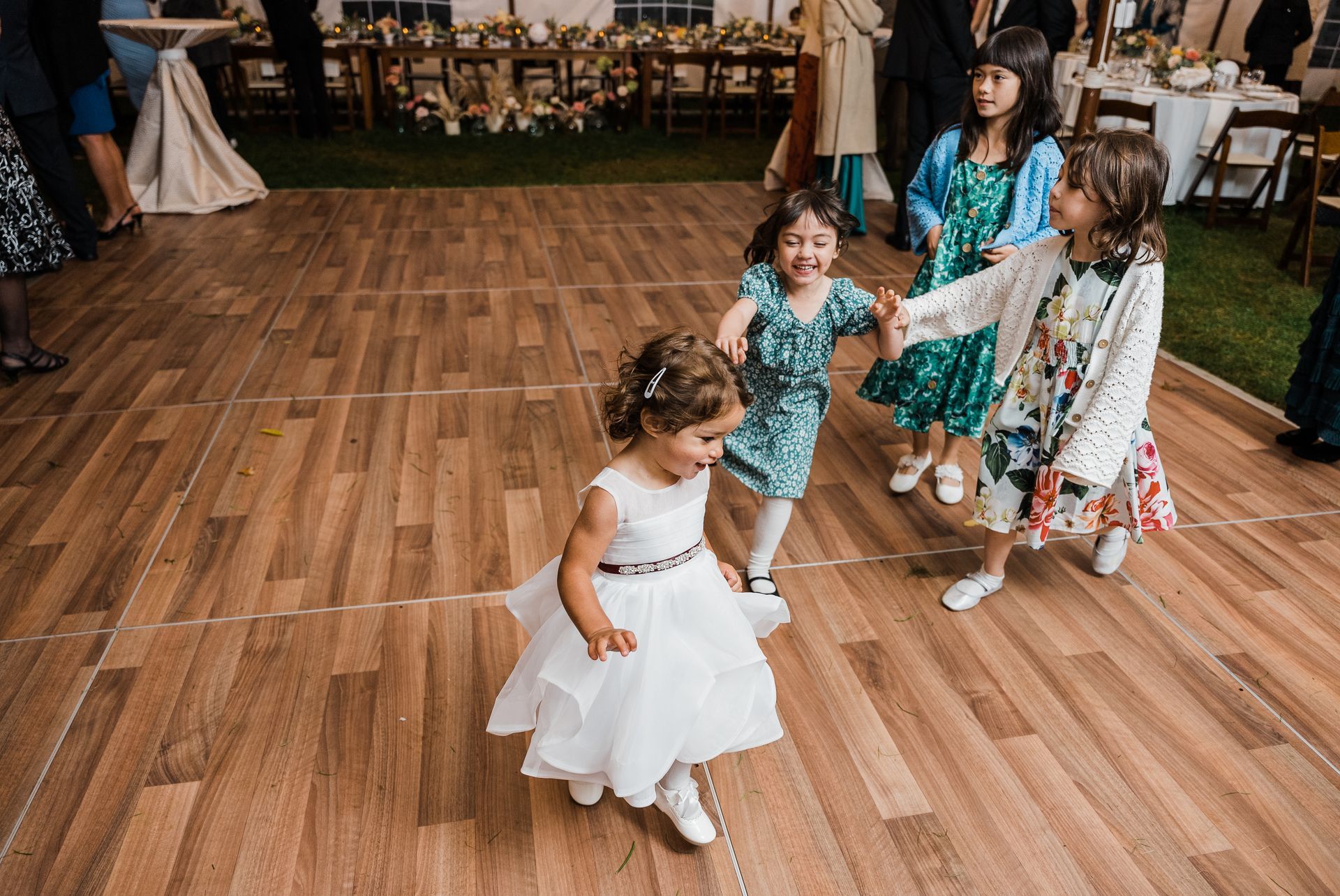 a group of little girls are dancing on a wooden dance floor