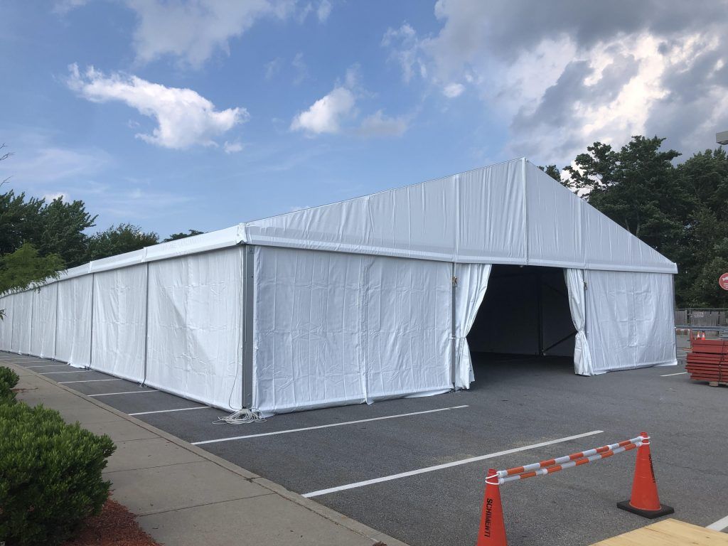 a large white tent is sitting in a parking lot