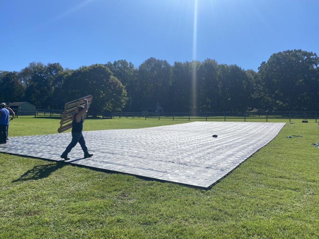 a man is carrying a large piece of wood in a field