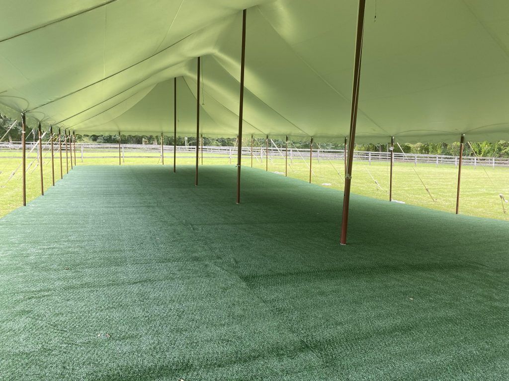 an empty tent with a green carpet underneath it