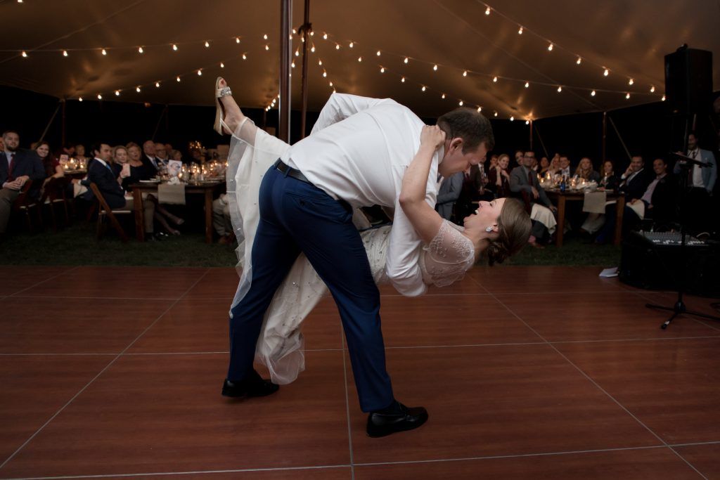 a bride and groom are dancing on a dance floor under a tent