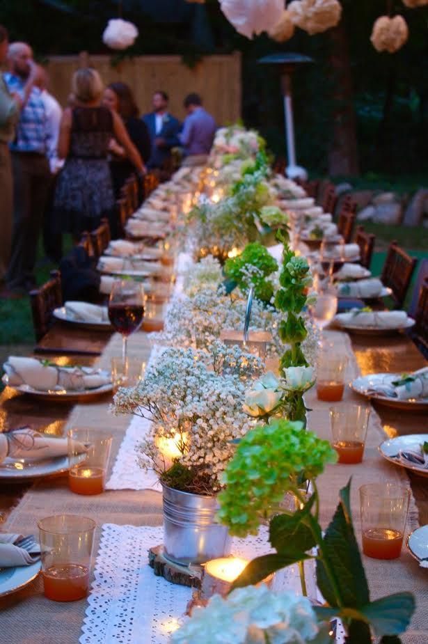a long table with flowers and candles on it