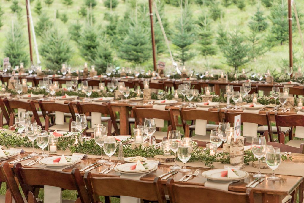 a long table is set for a wedding reception under a tent