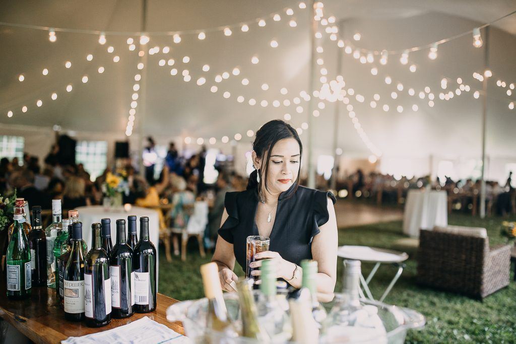 a woman is sitting at a table with bottles of wine