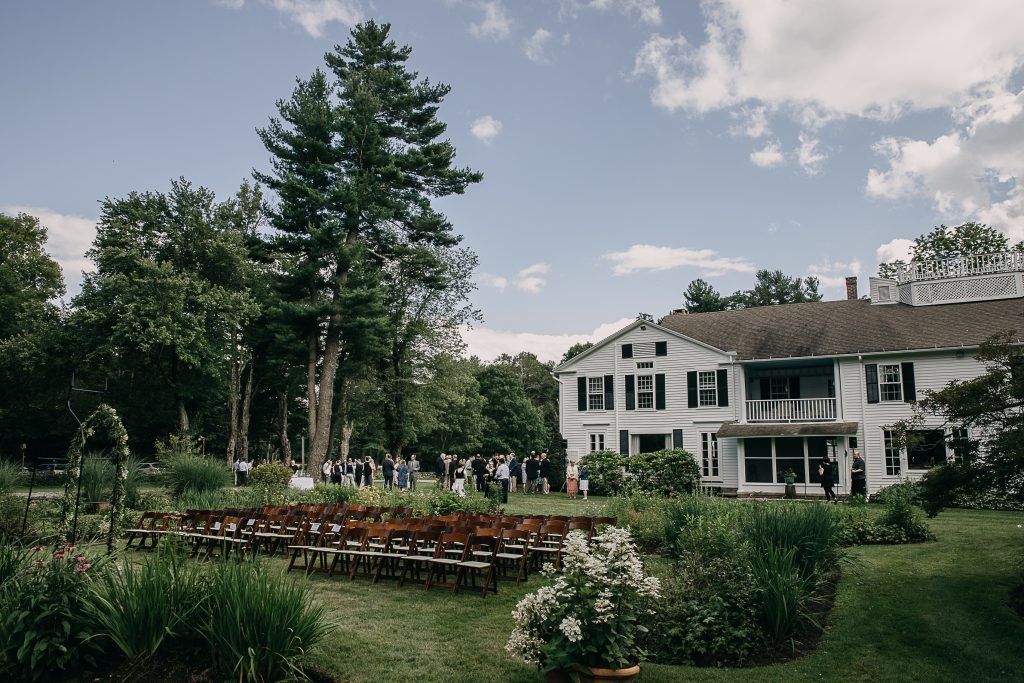 a large white house with a row of chairs in front of it