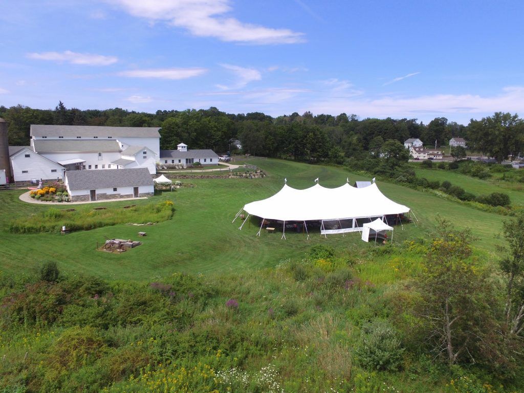 an aerial view of a large white tent in the middle of a grassy field