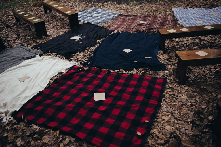 a bunch of blankets are laying on the ground next to benches