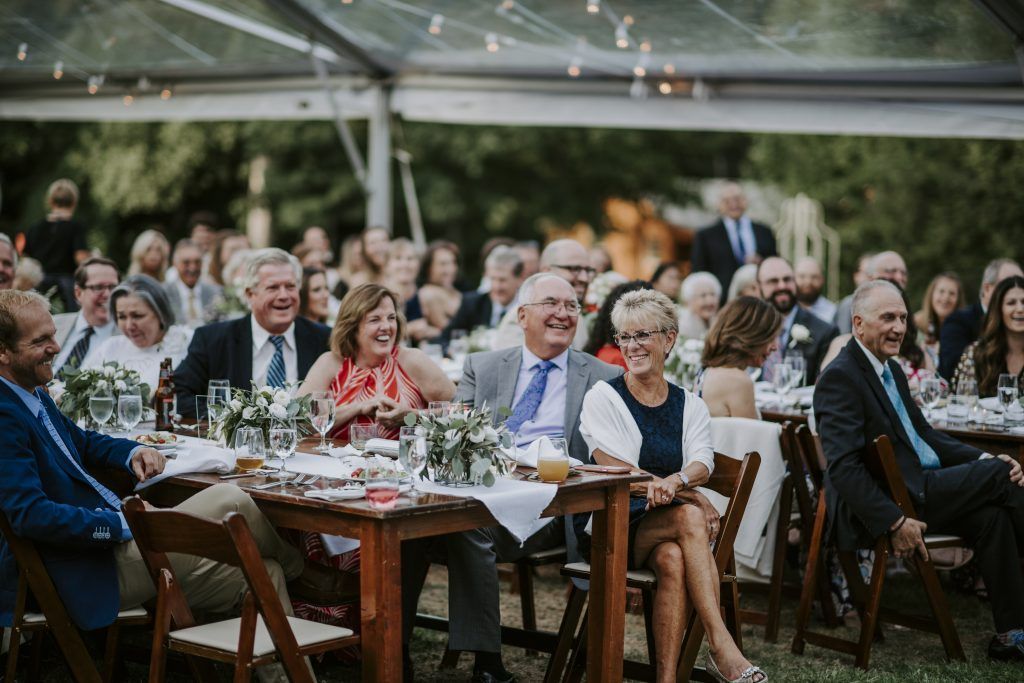 a large group of people are sitting at tables at a wedding reception