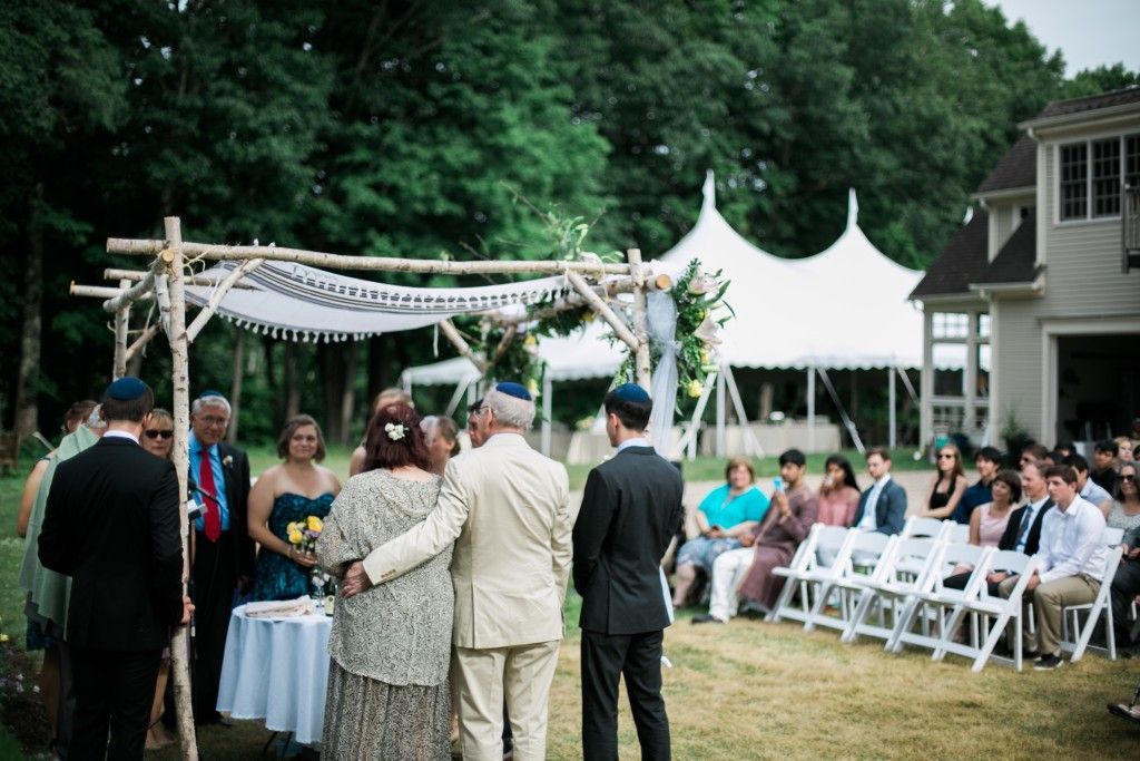 a group of people are standing in front of a tent at a wedding ceremony