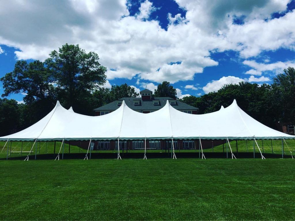 a large white tent is sitting in the middle of a grassy field