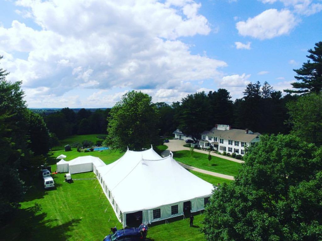 an aerial view of a large white tent in a grassy field