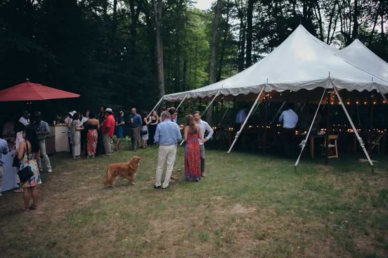 a group of people are standing in a field in front of a tent
