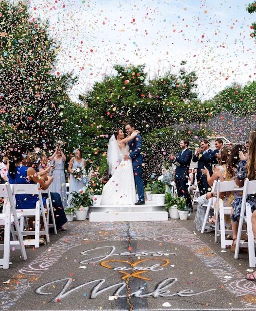 a bride and groom are kissing in front of a crowd of people at their wedding ceremony
