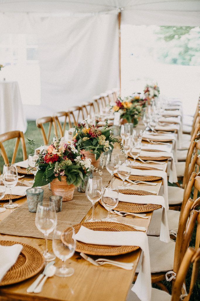 a long table set for a wedding reception under a tent