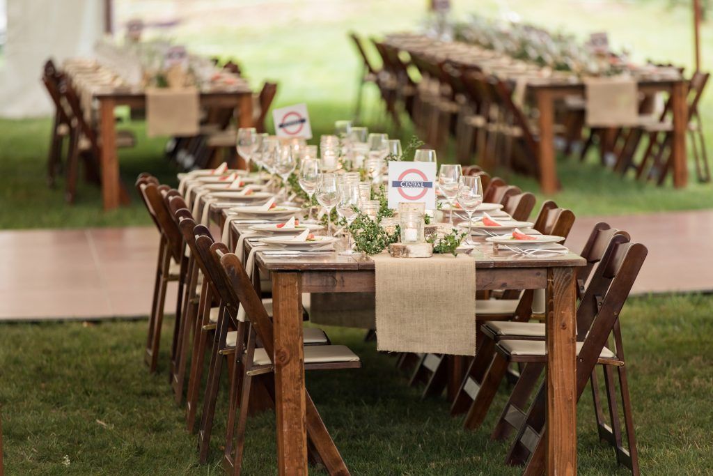 a long wooden table and chairs are set up for a wedding reception