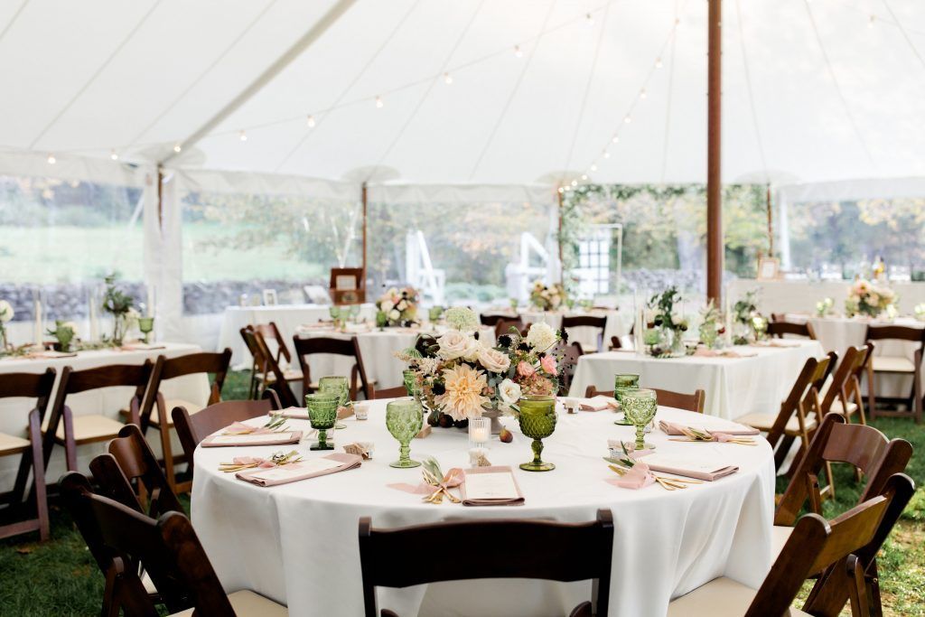 a tent with tables and chairs set up for a wedding reception