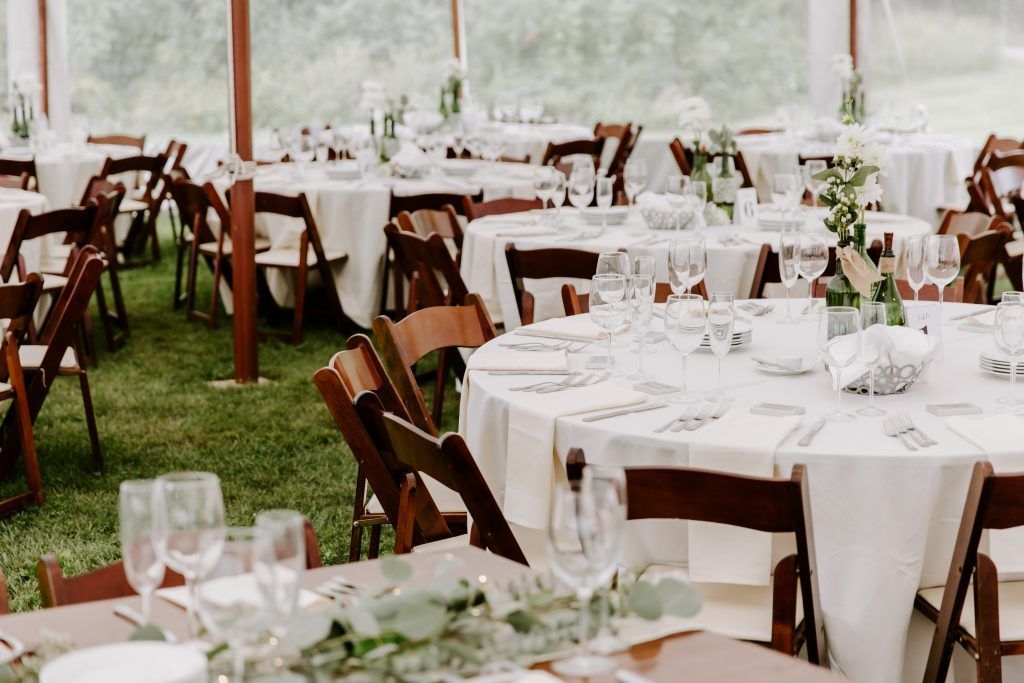 a tent with tables and chairs set up for a wedding reception