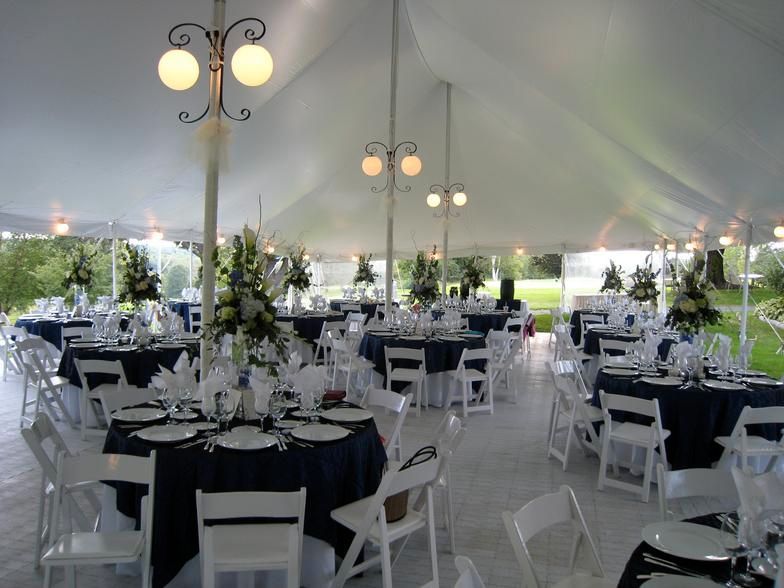 a large tent with tables and chairs set up for a wedding reception