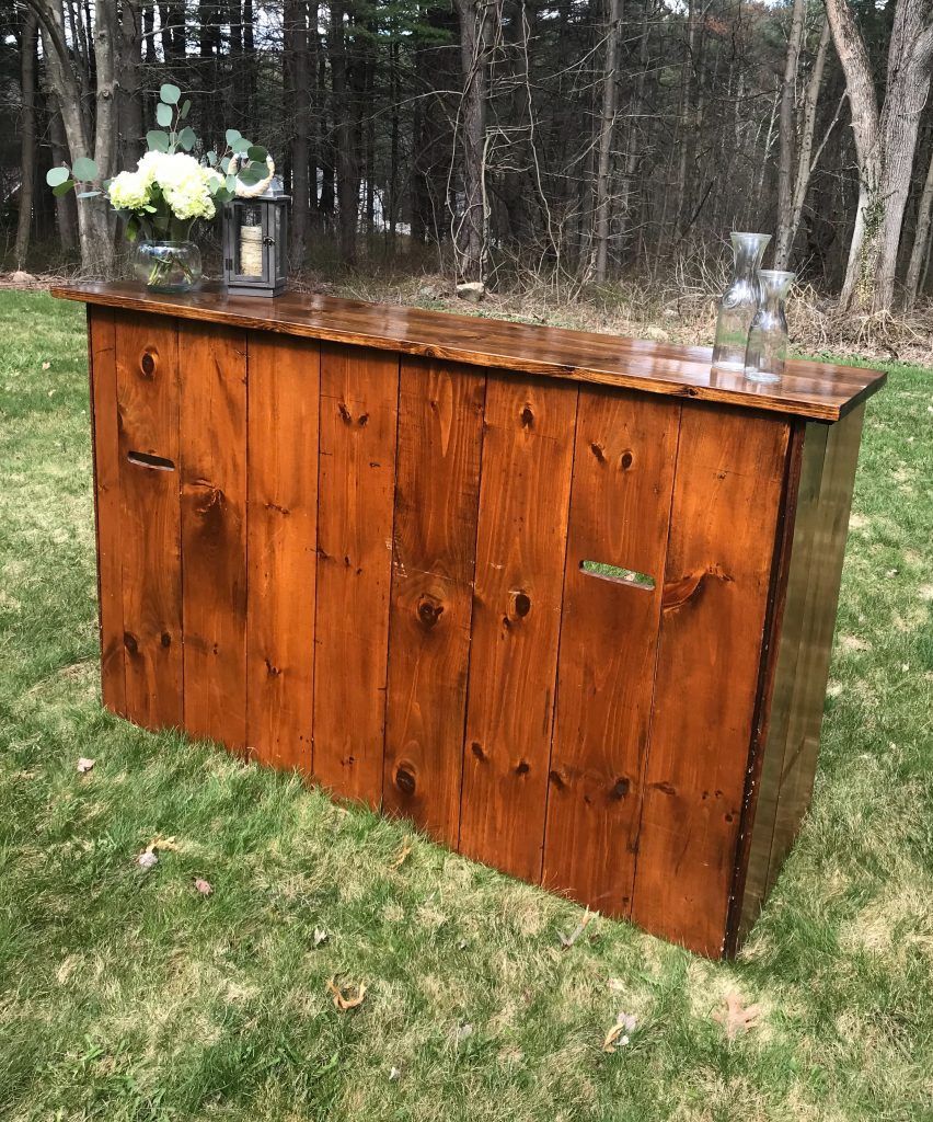 a wooden bar is sitting on top of a lush green field