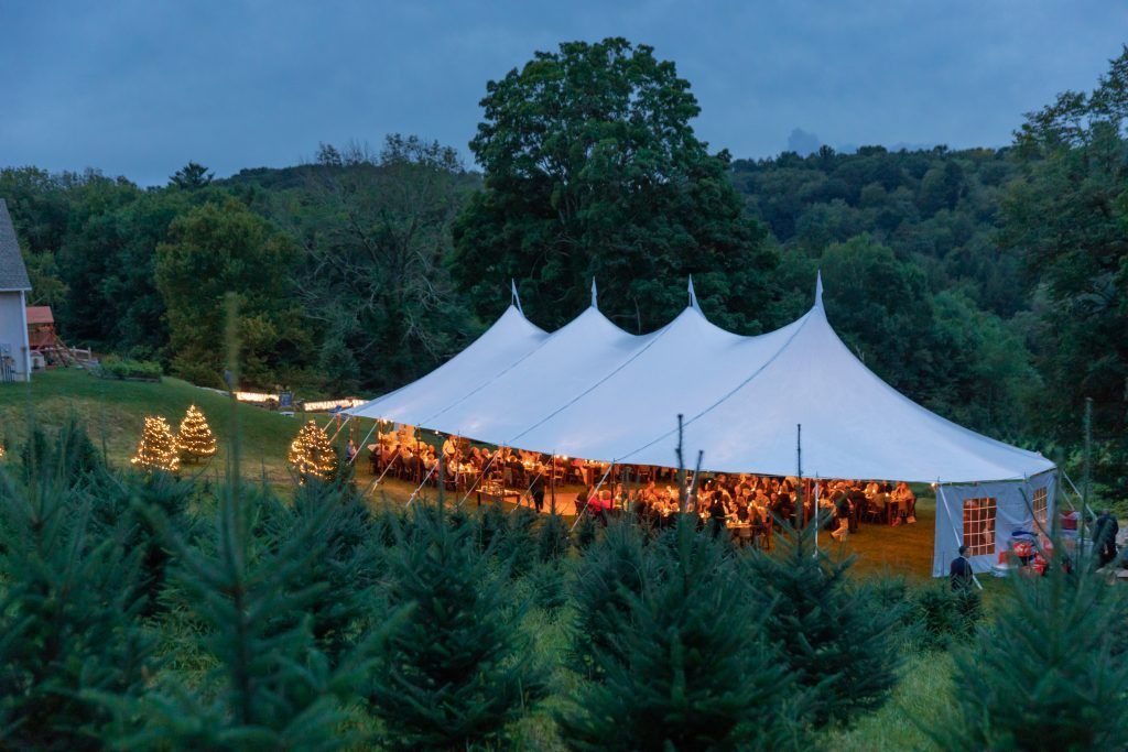 a large white tent is in the middle of a forest