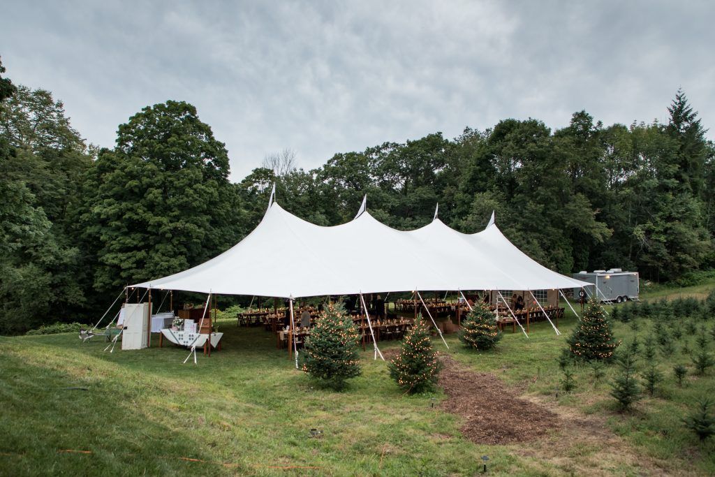 a large white tent is sitting in the middle of a grassy field
