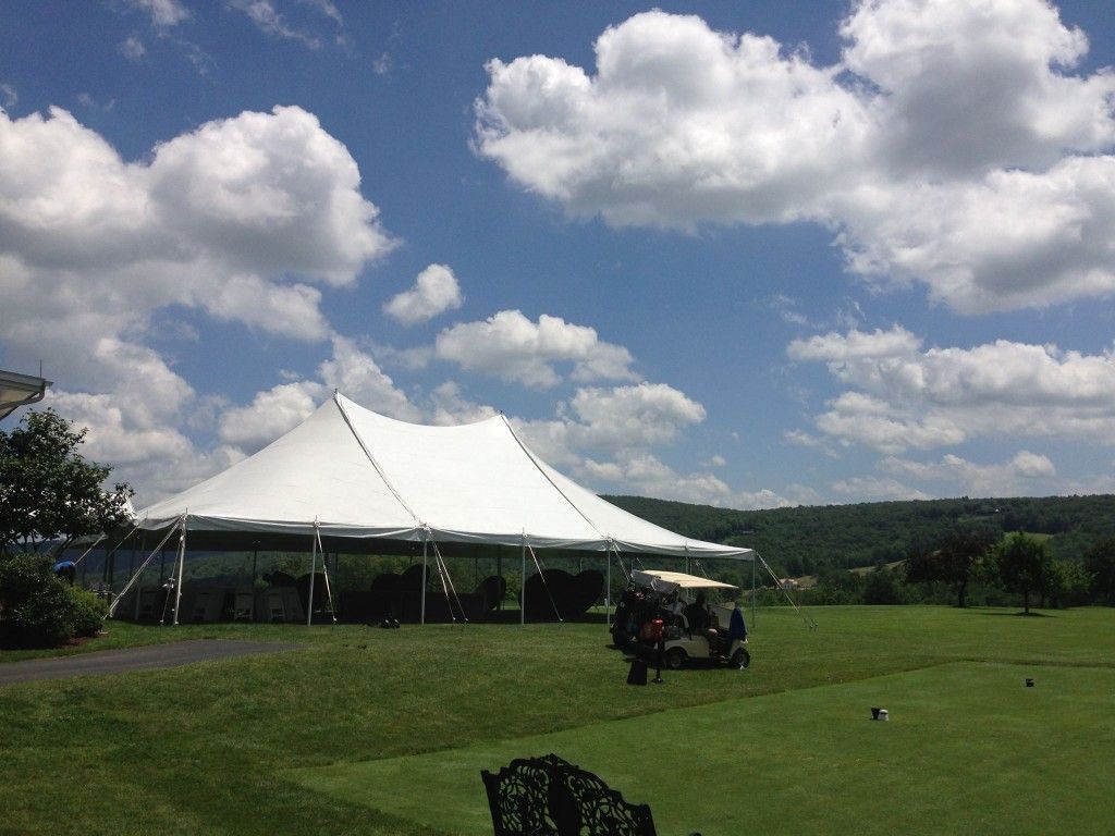 a large white tent is sitting in the middle of a grassy field
