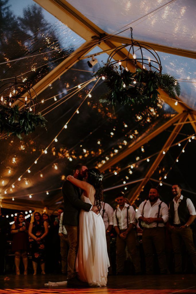 a bride and groom are dancing under a tent at their wedding reception