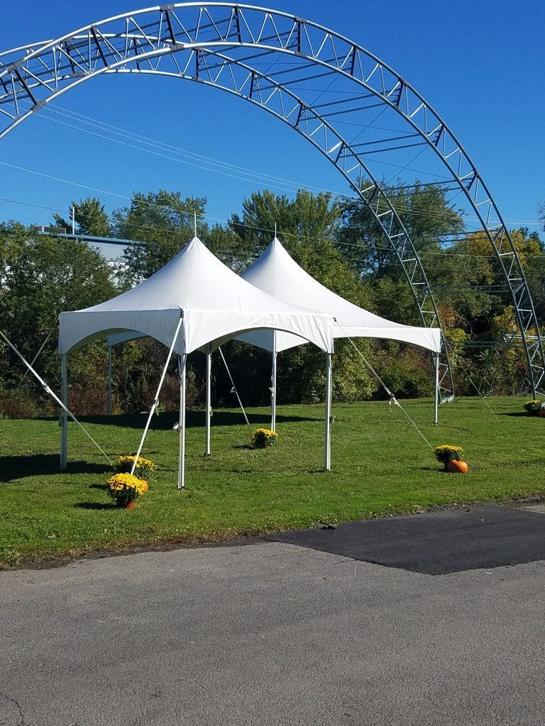 a couple of white tents are sitting on top of a lush green field