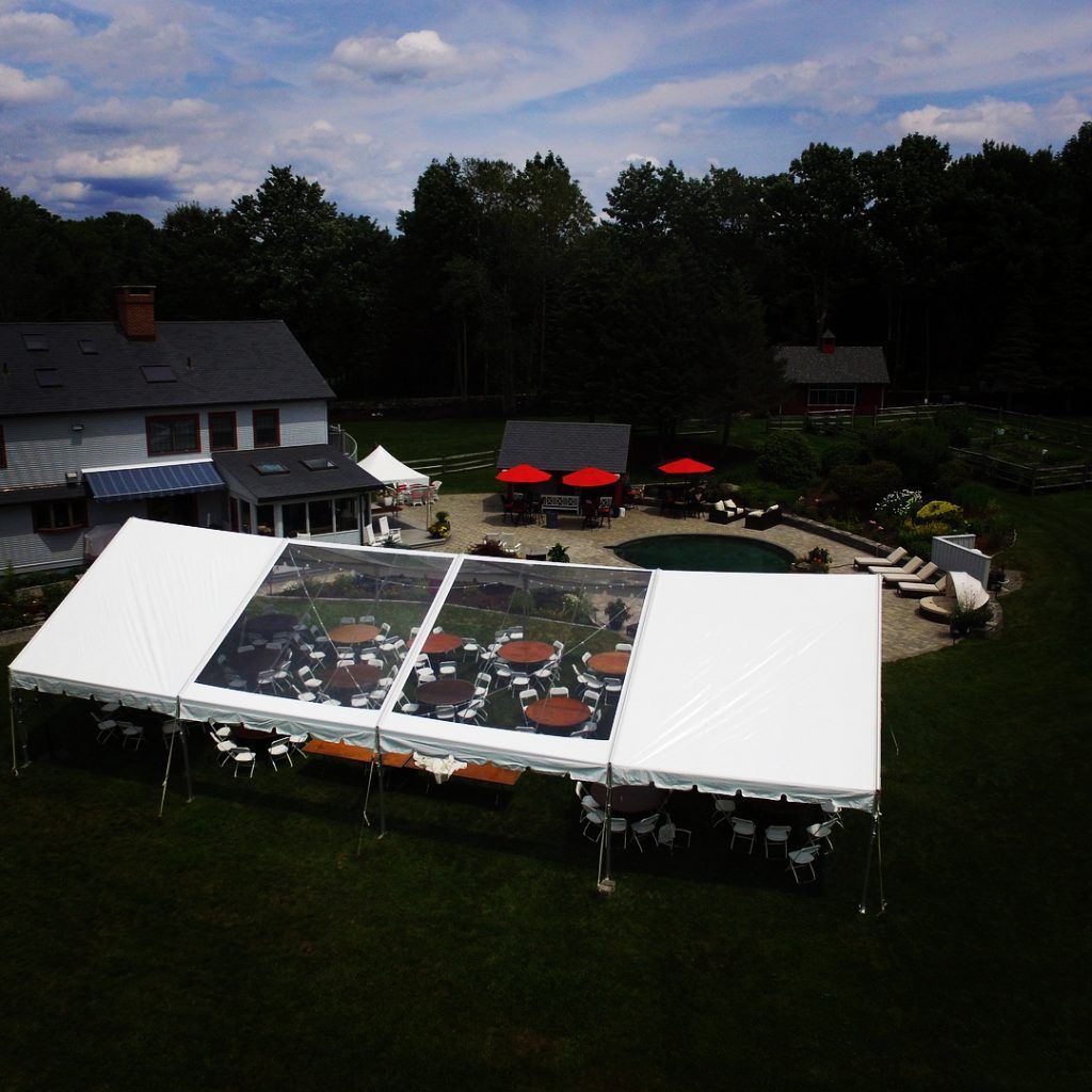 an aerial view of a large clear tent with tables and chairs underneath it