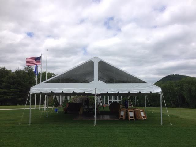 a large white tent is sitting in the middle of a grassy field