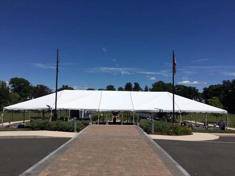 a large white tent is sitting in the middle of a parking lot